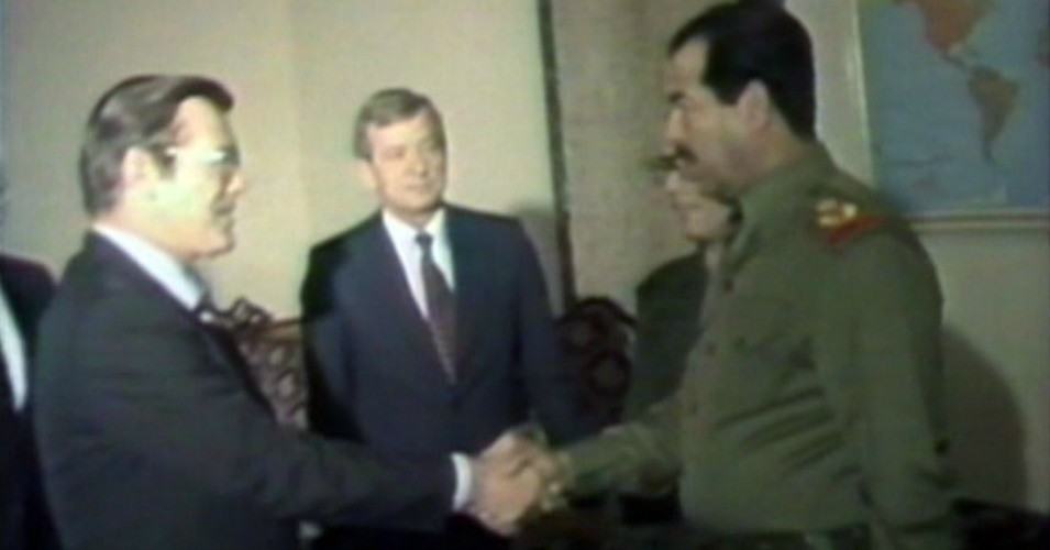 Iraqi President Saddam Hussein greets Donald Rumsfeld (1983) National Security Archive - Iraqi state television | Wikimedia Commons