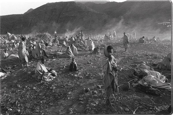 Ethiopia, 1985: Near a World Vision feeding center in Sanka, people rise with the dawn after sleeping outside all night, hoping to find relief from the famine that gripped the country (1985) Steve Reynolds | World Vision