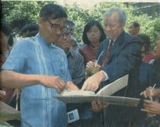 Ambassador Darryl Johnson and former teaching colleague Sumethee Srisaengkaew looking at old photos during a visit to Chakkhamkhanaton School in Lamphun (2002) | Friends of Thailand