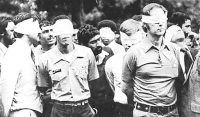 Blindfolded American hostages being led out by their Iranian captors with their hands behind their backs