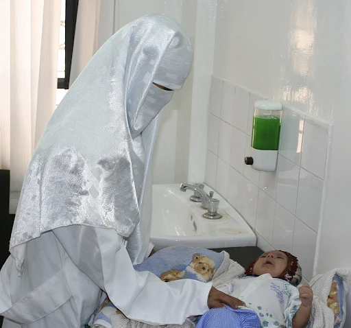 A Yemeni doctor examines an infant in a USAID-sponsored health care clinic. 2006, Ben Barber (USAID)
