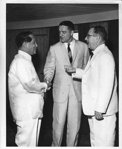 First Peace Corps Director R. Sargent Shriver (center) calls on President Carlos P. Garcia [left] on board the RPS Lapu-Lapu in Manila, Philippines, May 23, 1961. Introducing him to the President is U.S. Ambassador John D. Hickerson [right]. International Cooperation Administration (ICA). R. Sargent Shriver Personal Papers. John F. Kennedy Presidential Library and Museum, Boston