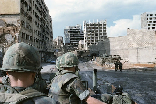 U.S. Marines patrol a shell-damaged section of Beirut in a truck. The Marines had been deployed in Lebanon as part of a multinational peacekeeping force following confrontation between Israeli forces and the Palestine Liberation Organization (01 April 1983) The U.S. National Archives | NARA & DVIDS Public Domain Archive