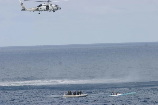 A U.S. Navy helicopter and crew members from the Navy and a Coast Guard Law Enforcement Detachment team approach a semi-submersible drug trafficking vessel off the coast of Ecuador. 
Source: https://is.gd/Uunzmr 