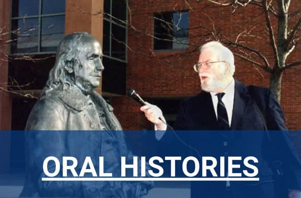 Charles Stuart Kennedy interviewing a bronze Benjamin Franklin on the campus of the Foreign Service Institute
